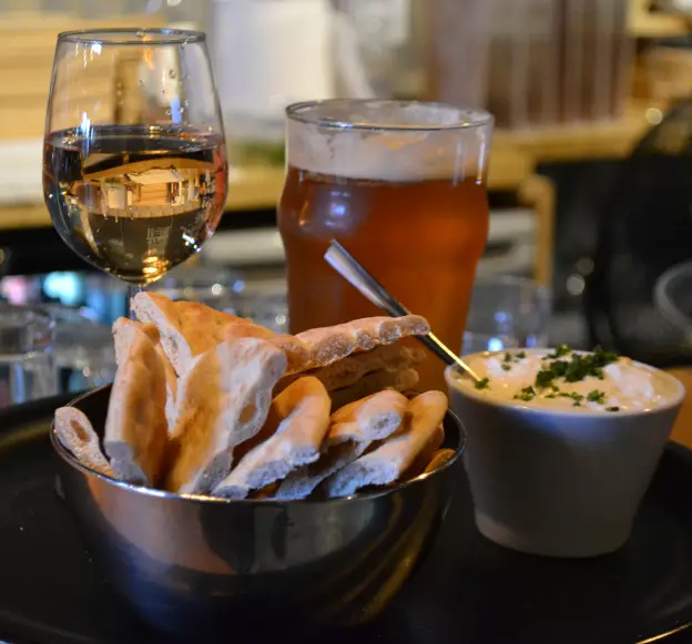 Pain grillé, dip maison, verre de vin blanc et pinte de bière